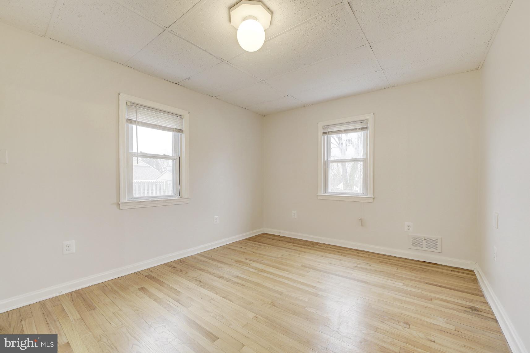 12216 Charles Road Silver Spring, MD 20906 - Photo 13 of 22 an empty room with wooden floor and windows
