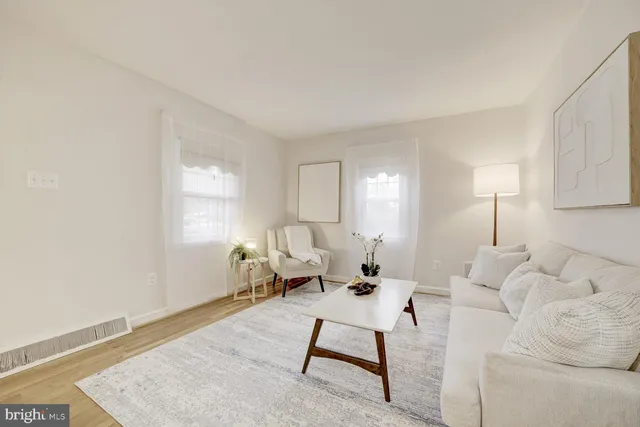 a dining room with chandelier and wooden floor