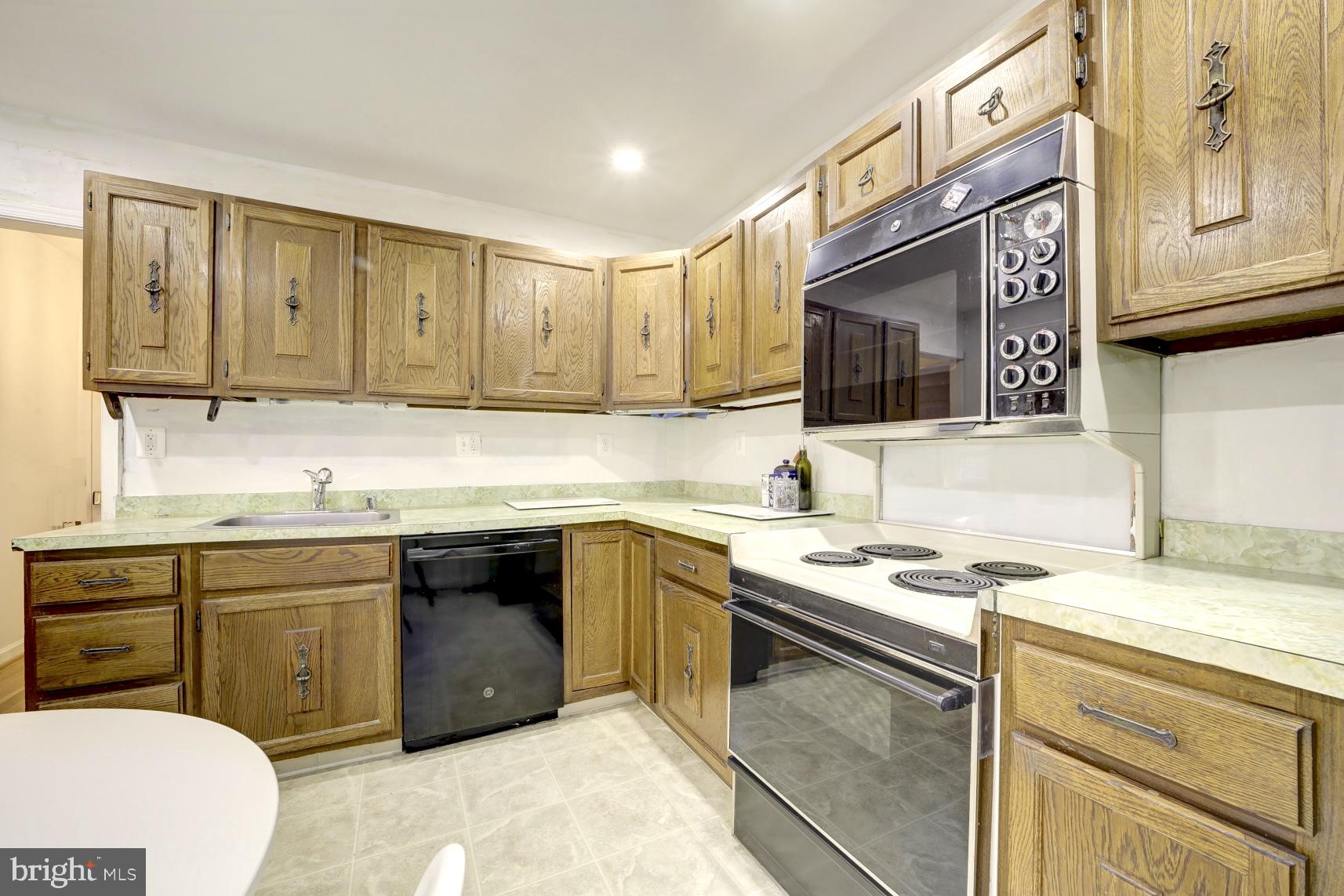 12216 Charles Road Silver Spring, MD 20906 - Photo 9 of 22 a kitchen with stainless steel appliances granite countertop a sink stove and cabinets