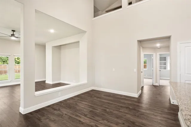 a dining room with wooden floor and large windows