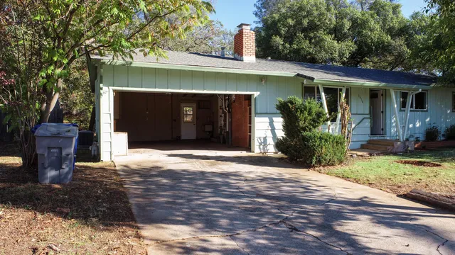 a front view of a house with a yard and potted plants