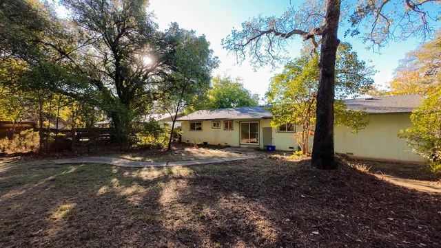 a view of a house with backyard and a tree