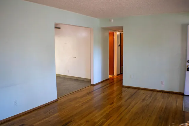 an empty room with wooden floor and closet