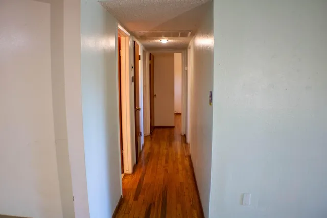 a view of a hallway with wooden floor