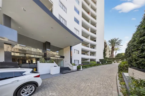 a large white kitchen with a large counter top appliances and cabinets