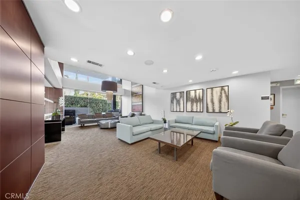 a living room with furniture a wooden floor and a flat screen tv