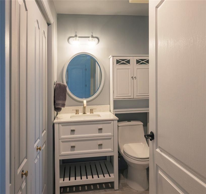 3475 Oak Valley Road Northeast, Unit 1450 Atlanta, GA 30326 - Photo 13 of 28 a bathroom with a toilet a sink and a mirror