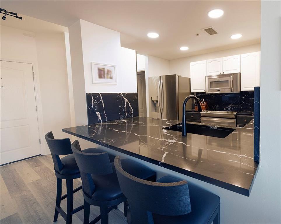 3475 Oak Valley Road Northeast, Unit 1450 Atlanta, GA 30326 - Photo 17 of 28 a kitchen with stainless steel appliances granite countertop a sink and a refrigerator
