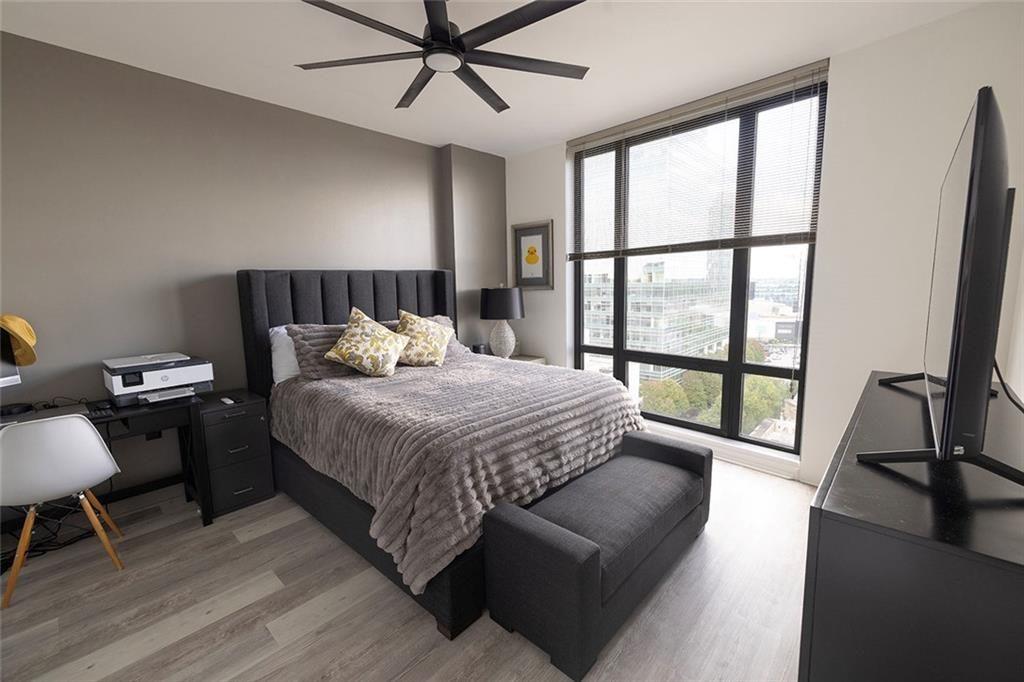 3475 Oak Valley Road Northeast, Unit 1450 Atlanta, GA 30326 - Photo 6 of 28 a bedroom with a bed a couch and a large window