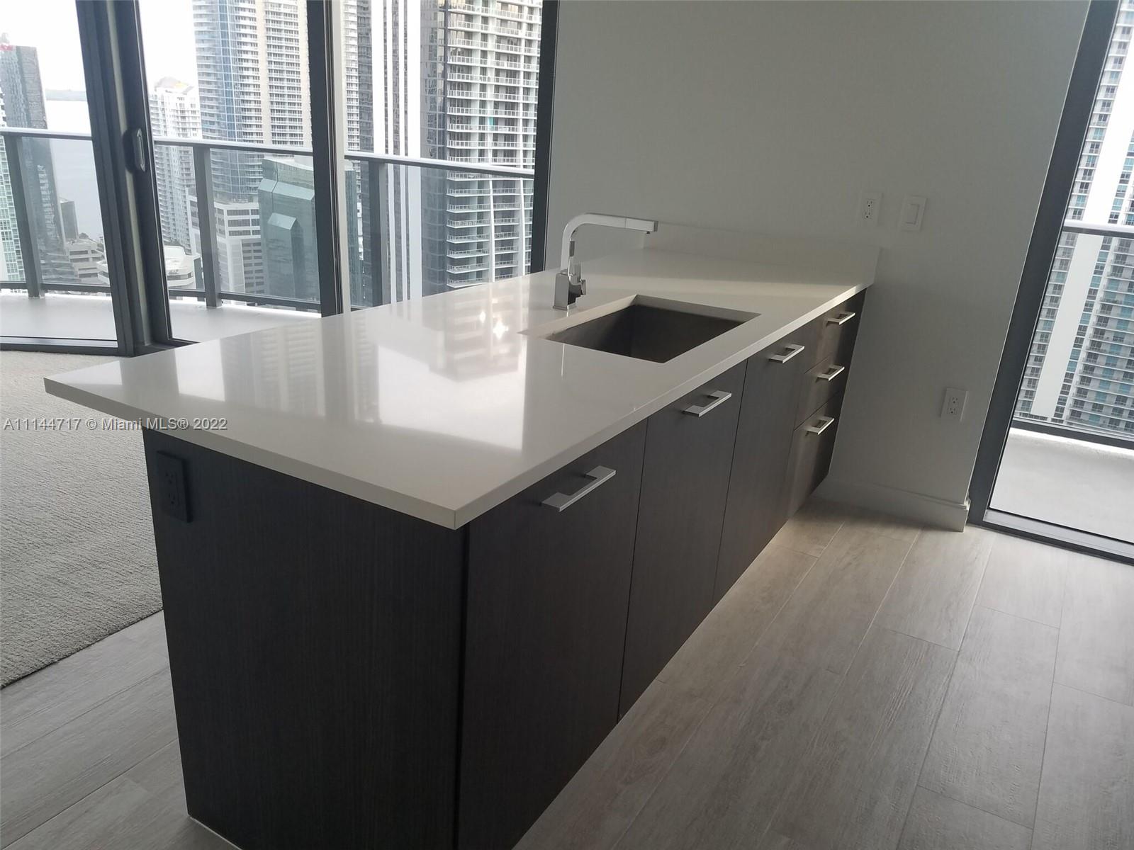 45 Southwest 9th Street, Unit 3103 Miami, FL 33130 - Photo 11 of 23 a kitchen with a sink a counter top space and a window