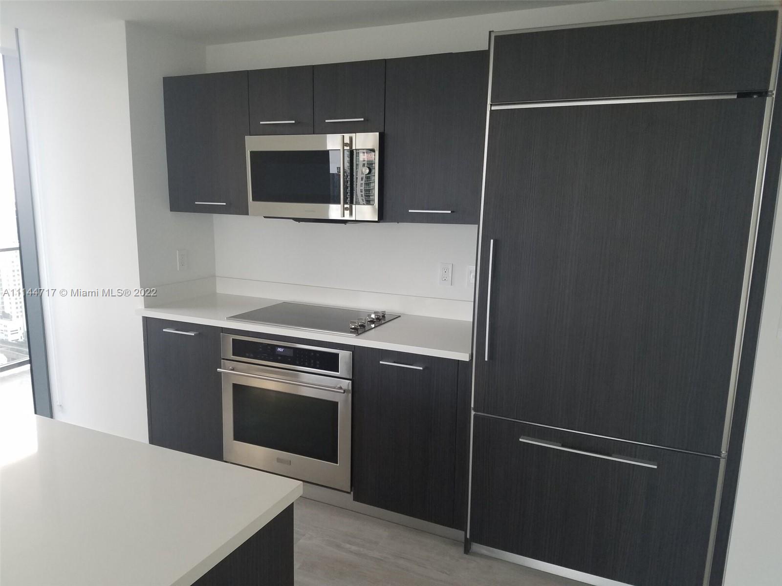 45 Southwest 9th Street, Unit 3103 Miami, FL 33130 - Photo 10 of 23 a kitchen with a refrigerator and a microwave