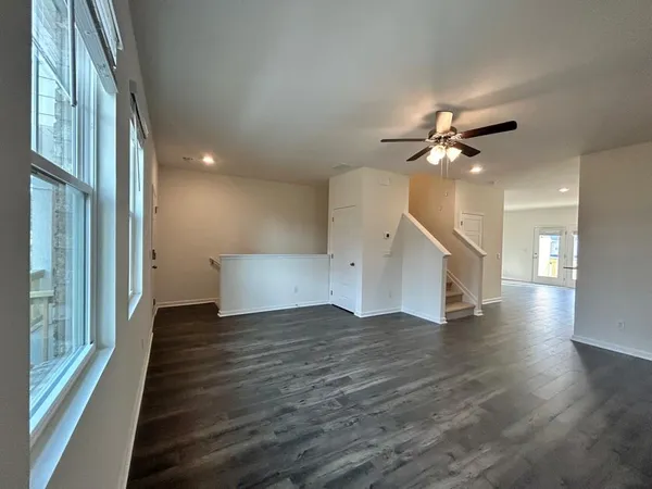 a view of a livingroom with wooden floor and a ceiling fan