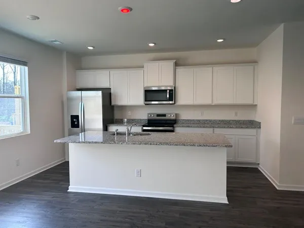 a kitchen with stainless steel appliances granite countertop a stove a sink and a refrigerator