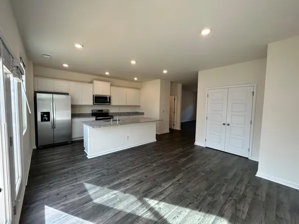 a view of kitchen with stainless steel appliances kitchen island granite countertop a refrigerator and a stove top oven