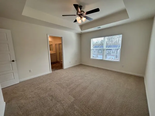 an empty room with windows and fan