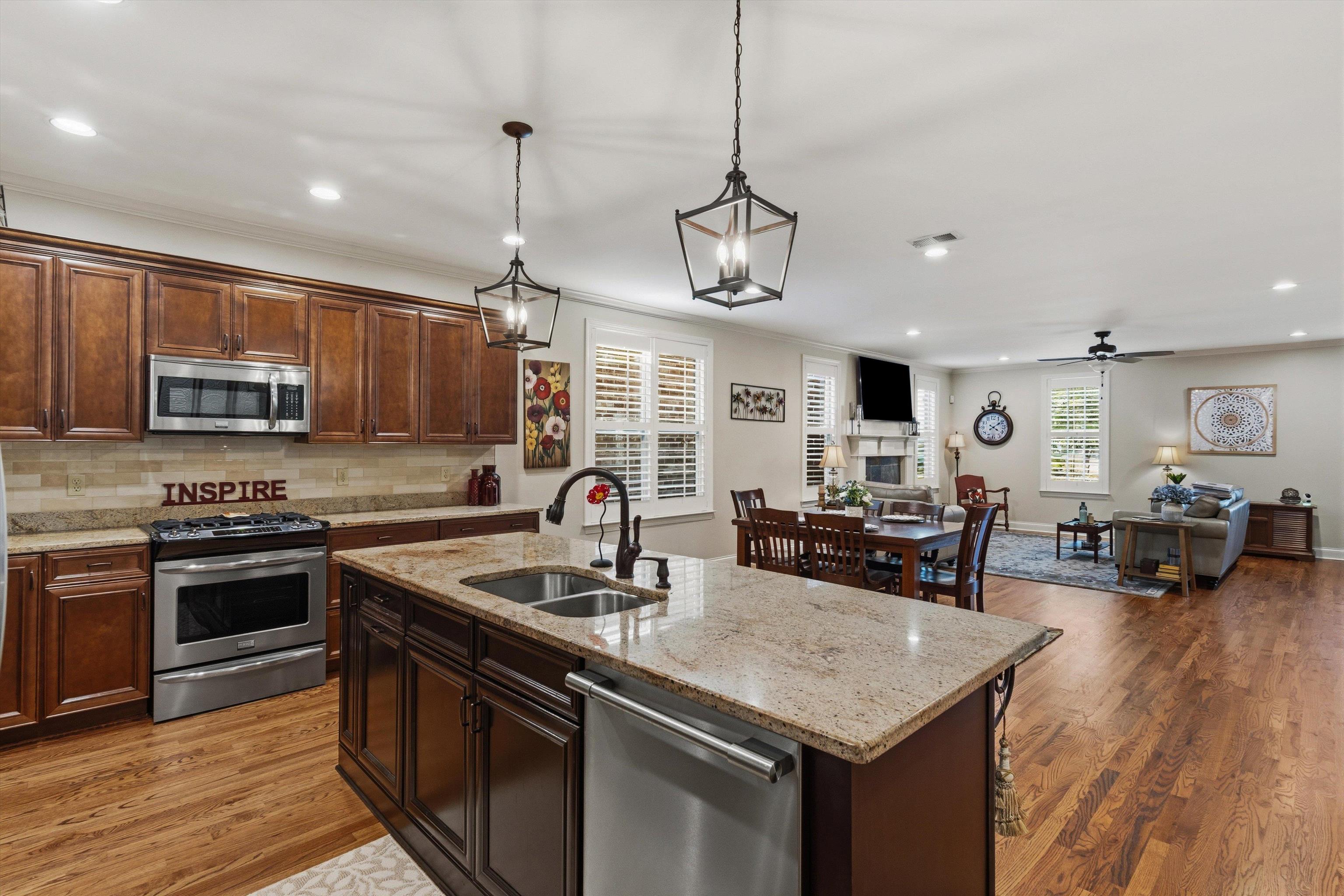 1011 Ostlers Way Collierville, TN 38017 - Photo 13 of 31 a kitchen with stainless steel appliances granite countertop a sink dishwasher stove and oven with wooden floor