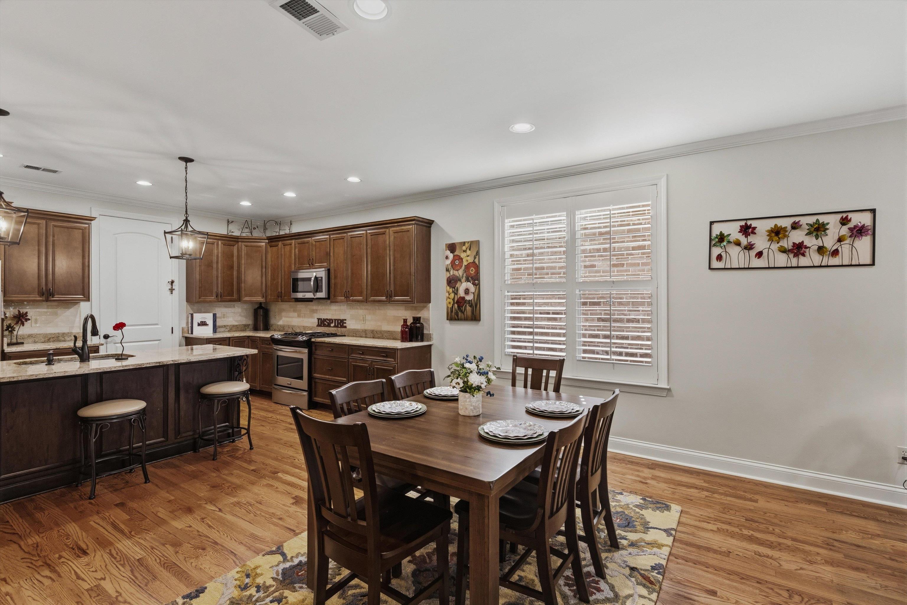 1011 Ostlers Way Collierville, TN 38017 - Photo 8 of 31 a kitchen with a dining table chairs and wooden floor