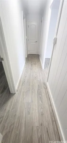 a view of a hallway in a house with wooden floor