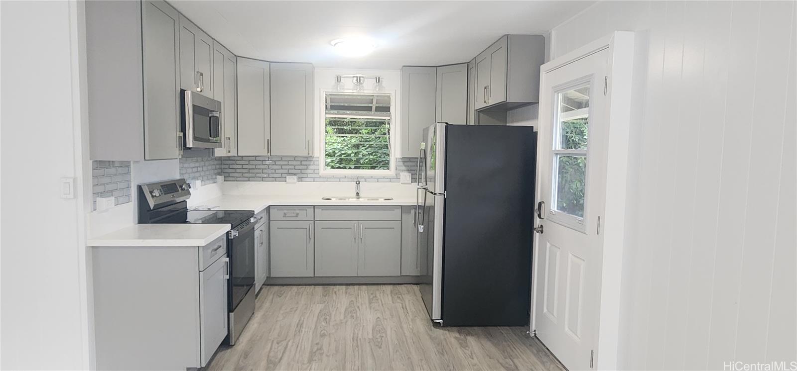41-978B Waikupanaha Street, Unit B4 Waimanalo, HI 96795 - Photo 3 of 18 a kitchen with a refrigerator sink and stove