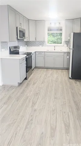 a kitchen with stainless steel appliances a refrigerator sink and microwave