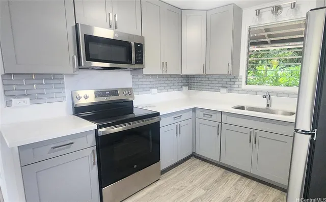 a kitchen with a sink stove and microwave