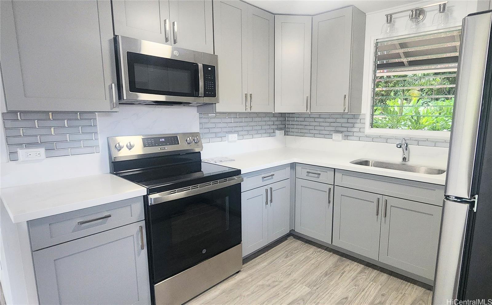 41-978B Waikupanaha Street, Unit B4 Waimanalo, HI 96795 - Photo 5 of 18 a kitchen with a sink stove and microwave