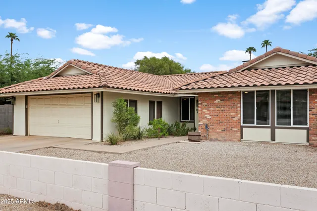 a front view of a house with a garden and garage