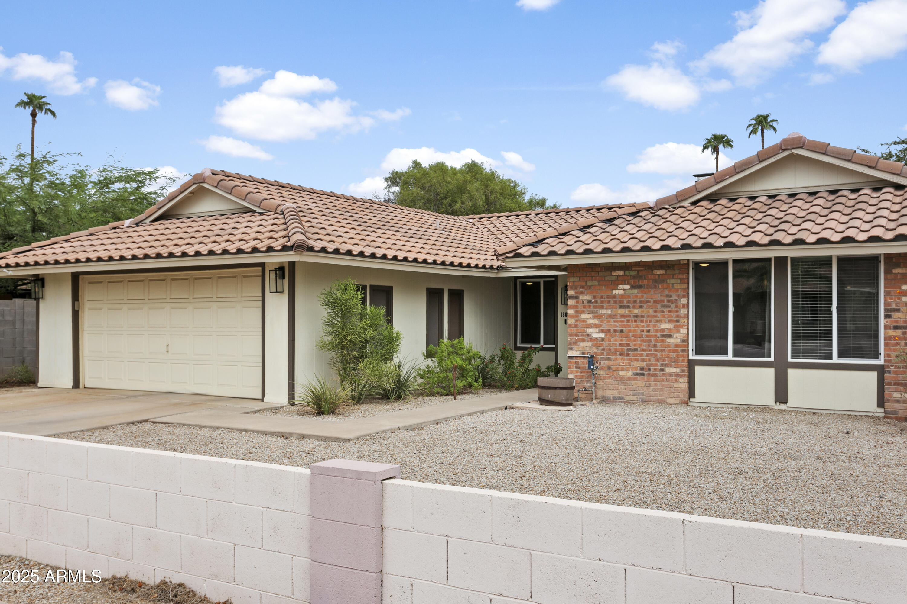 a front view of a house with a garden and garage