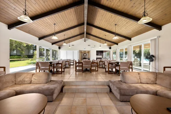 a living room with furniture a ceiling fan and a large window