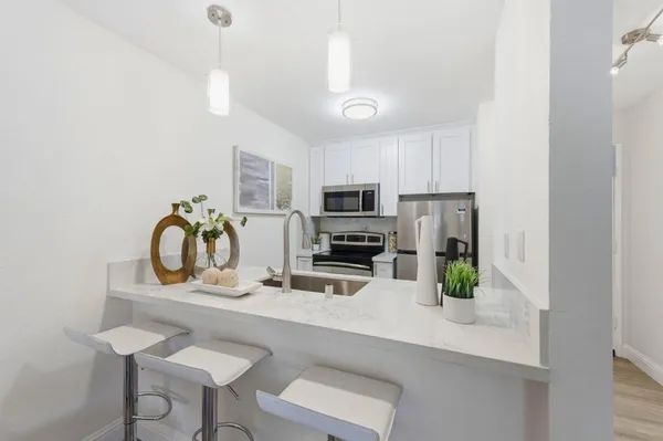 a kitchen with stainless steel appliances kitchen island granite countertop a refrigerator a stove a sink and a microwave