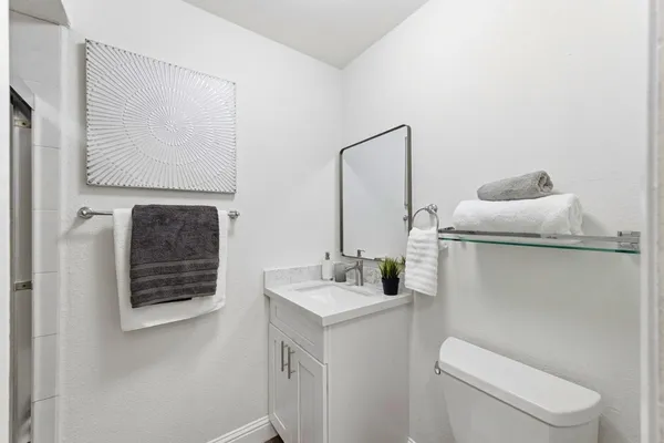a bathroom with a toilet sink and mirror