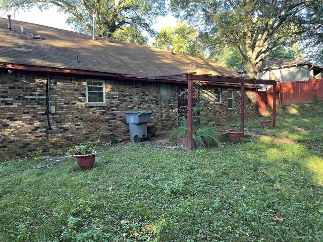 1601 Oberle Road Memphis, TN 38127 - Photo 18 of 20 a backyard of a house with wooden fence and a large tree