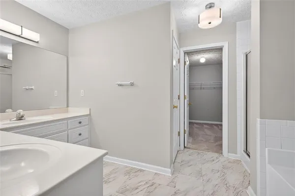 a spacious bathroom with a sink mirror and shower