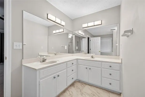 a spacious bathroom with a double vanity sink and mirror