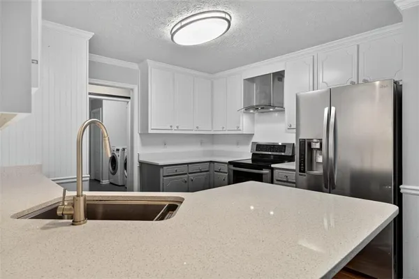 a kitchen with a refrigerator a sink a stove and cabinets