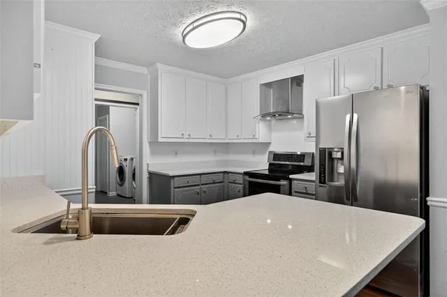 a kitchen with a refrigerator a sink a stove and cabinets