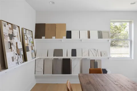 a living room with stainless steel appliances furniture a fireplace and a large window