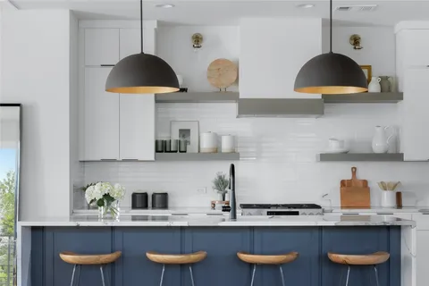 a kitchen with stainless steel appliances granite countertop a sink a stove and a wooden floors