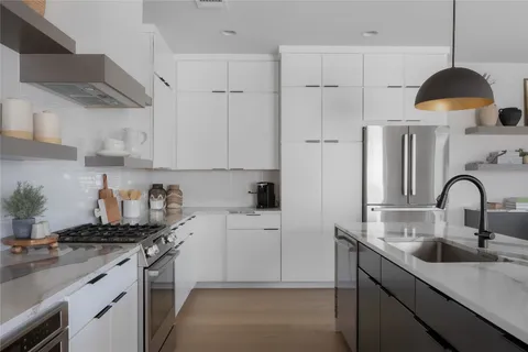 a kitchen with a sink a stove and cabinets