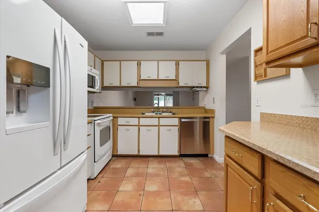 a kitchen with a white stove top oven and cabinets