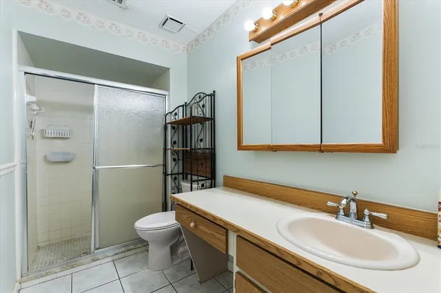 an empty room with wooden floor chandelier fan and windows