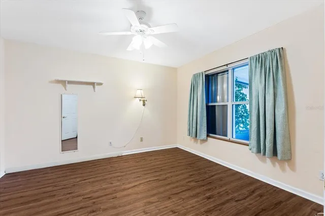 an empty room with wooden floor and window