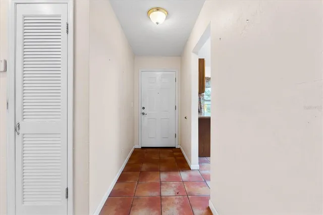 a view of a hallway with wooden floor and a bathroom