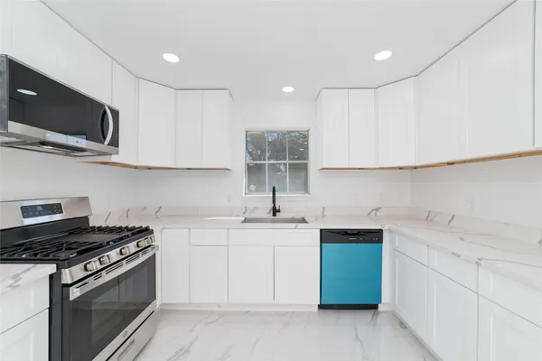 a kitchen with granite countertop a stove and a microwave