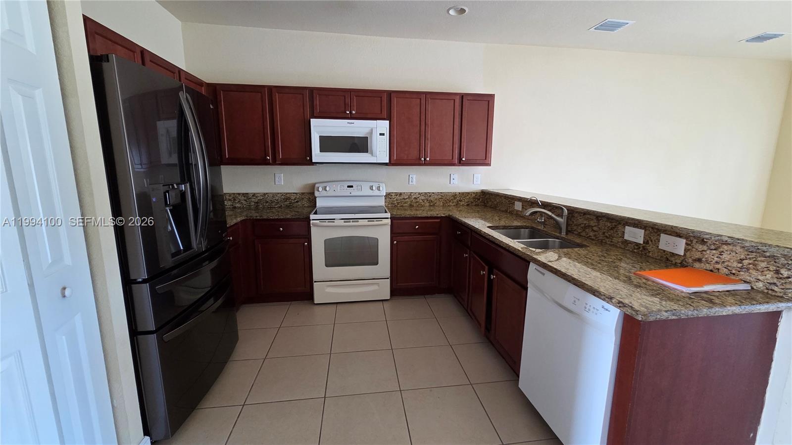 9001 Southwest 227th Street, Unit 7 Cutler Bay, FL 33190 - Photo 5 of 13 a kitchen with granite countertop stainless steel appliances a stove a microwave a sink and dishwasher