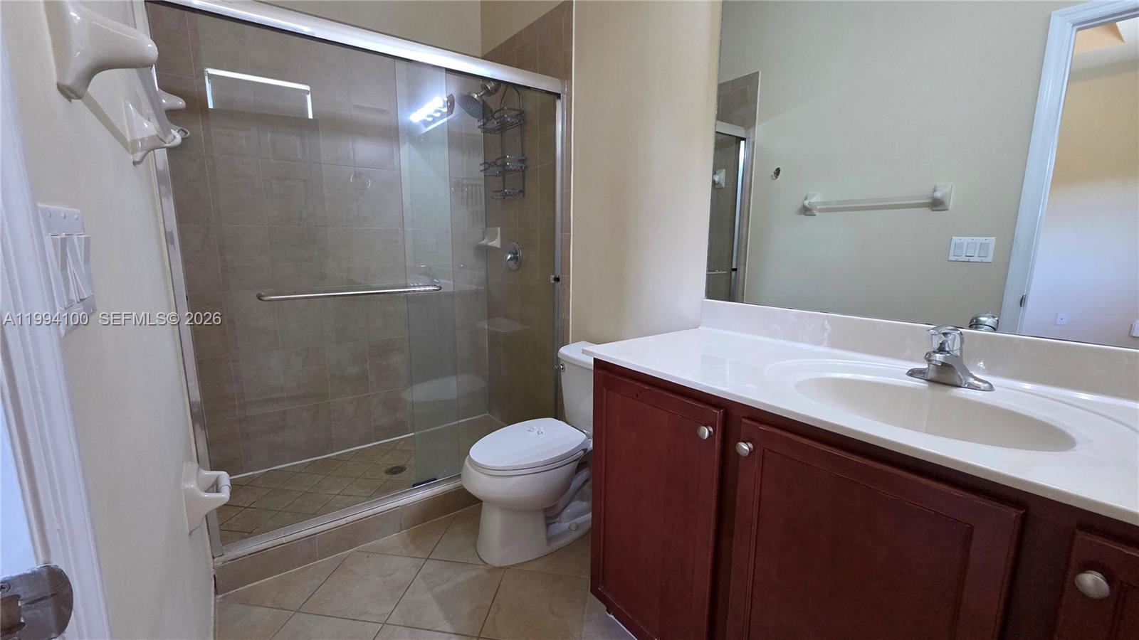 9001 Southwest 227th Street, Unit 7 Cutler Bay, FL 33190 - Photo 8 of 13 a bathroom with a sink mirror toilet and shower