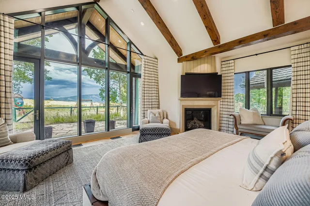 a large bedroom with a large window and a flat screen tv