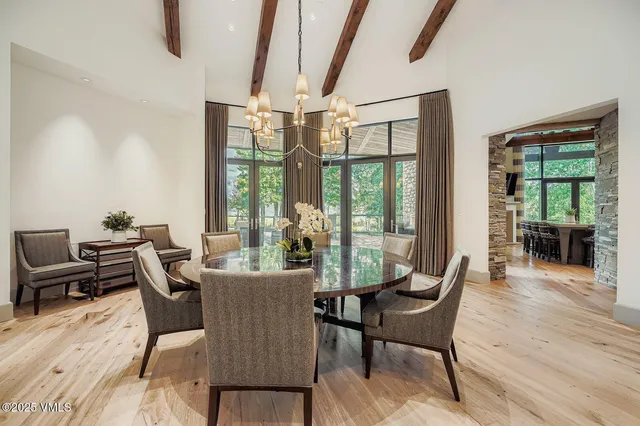 a dining room with furniture a chandelier and wooden floor