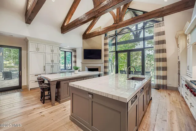 a kitchen with a stove a sink dishwasher and a refrigerator with wooden floor