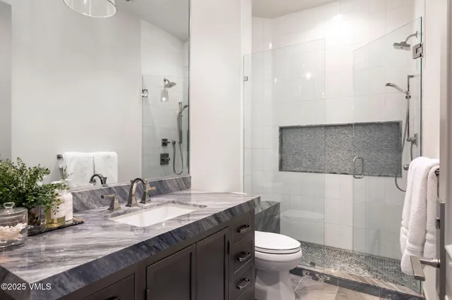a bathroom with a granite countertop sink toilet and shower